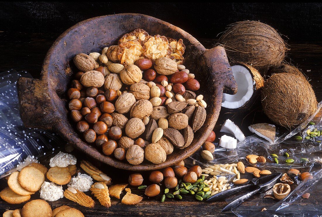 Still life with various nuts in wooden bowl & nut biscuits