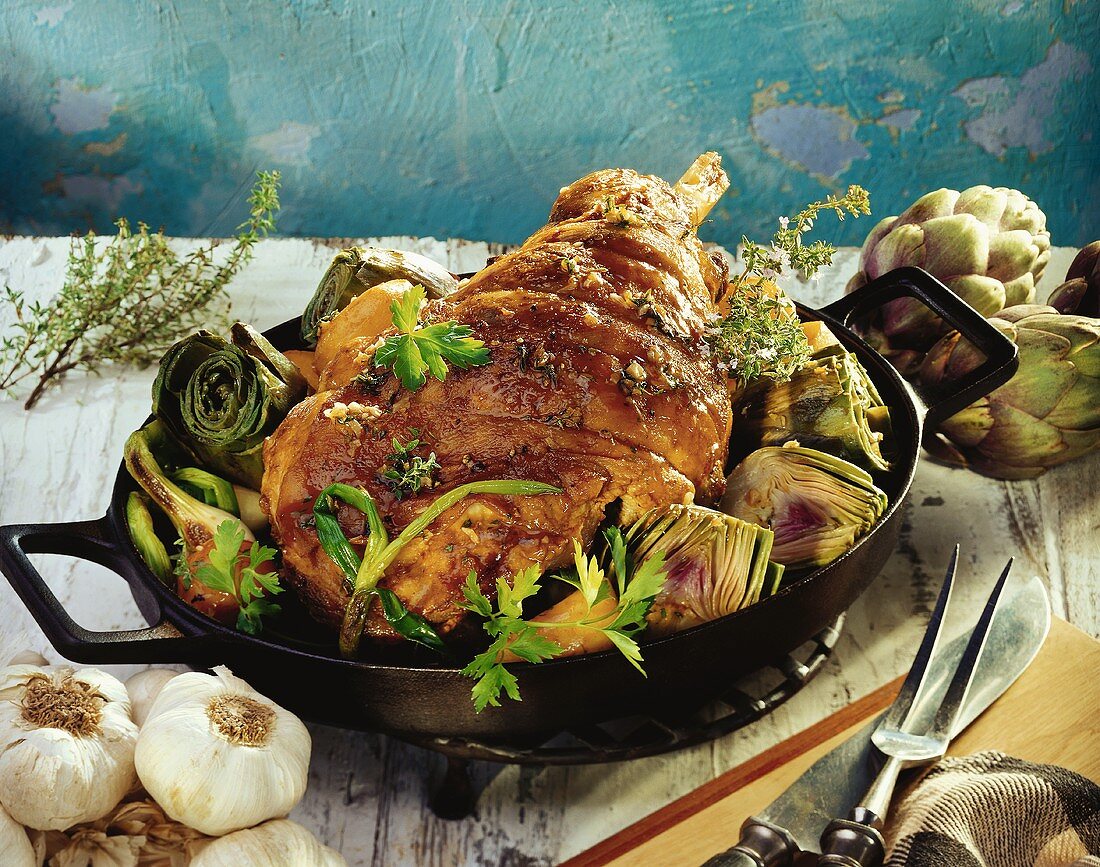Leg of lamb with artichokes and spring onions in pan