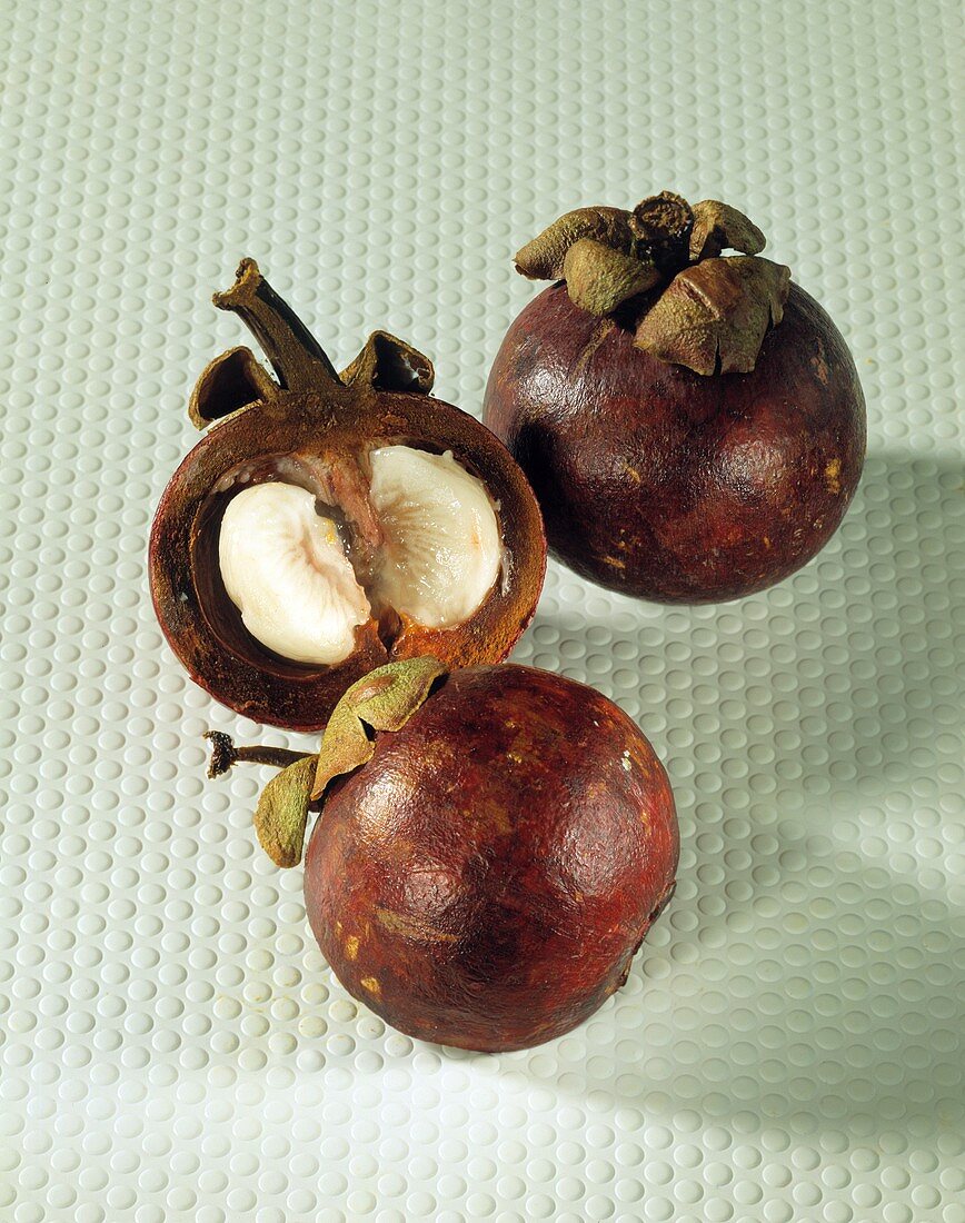 Two mangosteens and half a mangosteen
