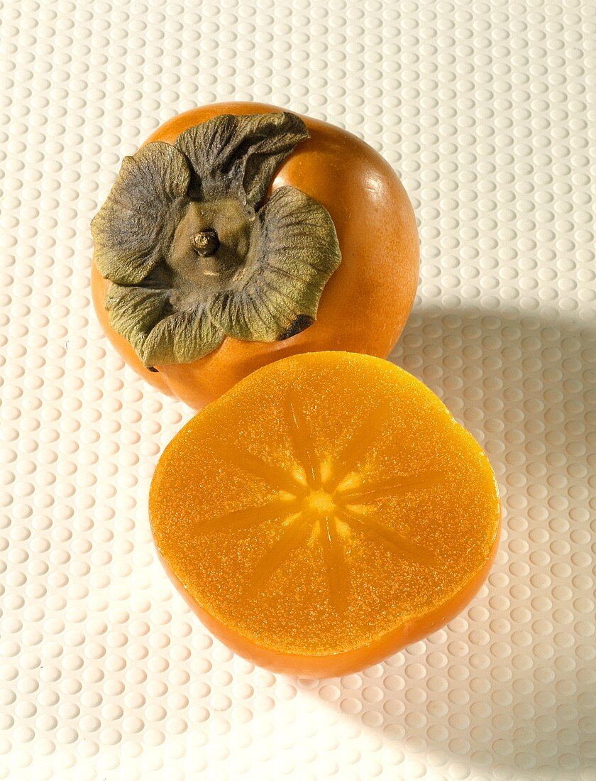 Sharon fruit, with halved  fruit in front