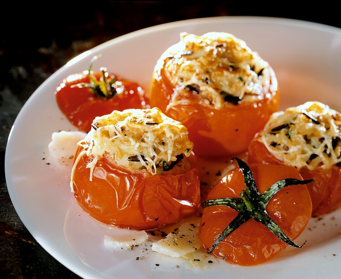 Stuffed grilled tomatoes with rice and cheese on plate