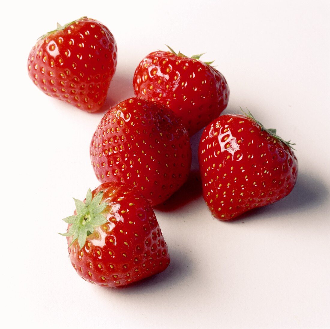 Fünf Erdbeeren auf weißem Untergrund