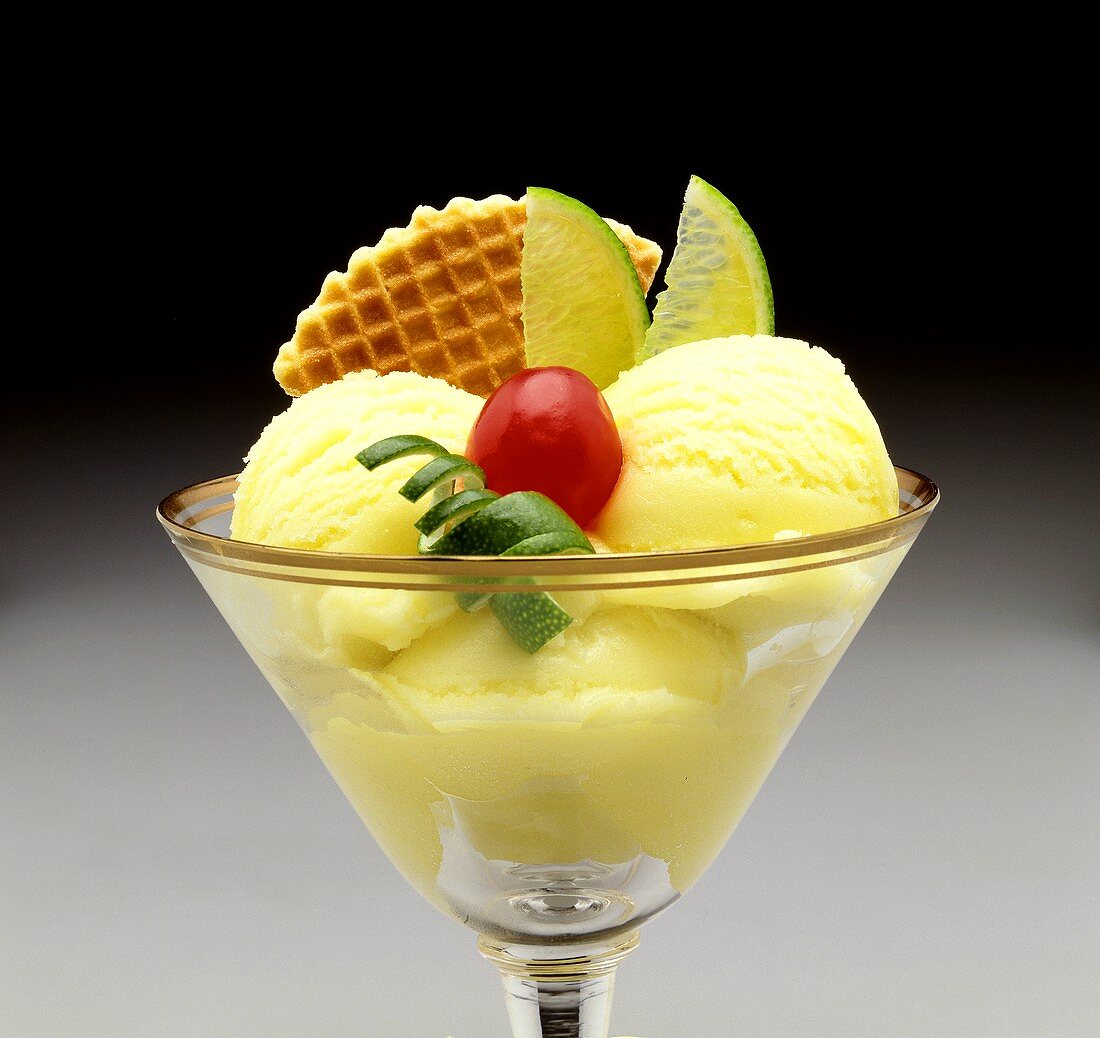 Lime sundae with lime slices, cherry and wafer
