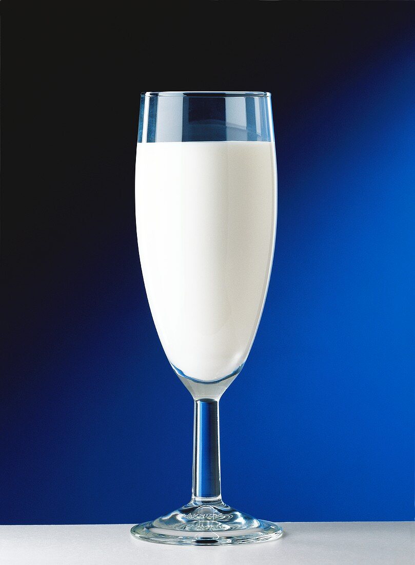 Ein Glas Milch vor schwarzblauem Hintergrund