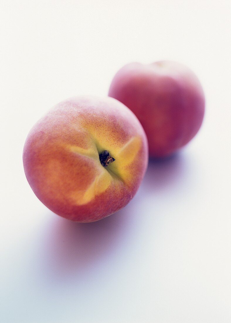 Two peaches on white background