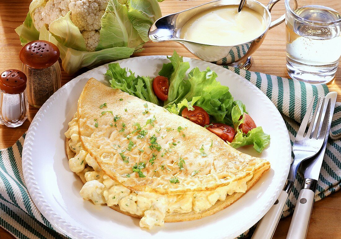 Omelett mit Blumenkohl und Salat auf Teller; Bechamelsauce