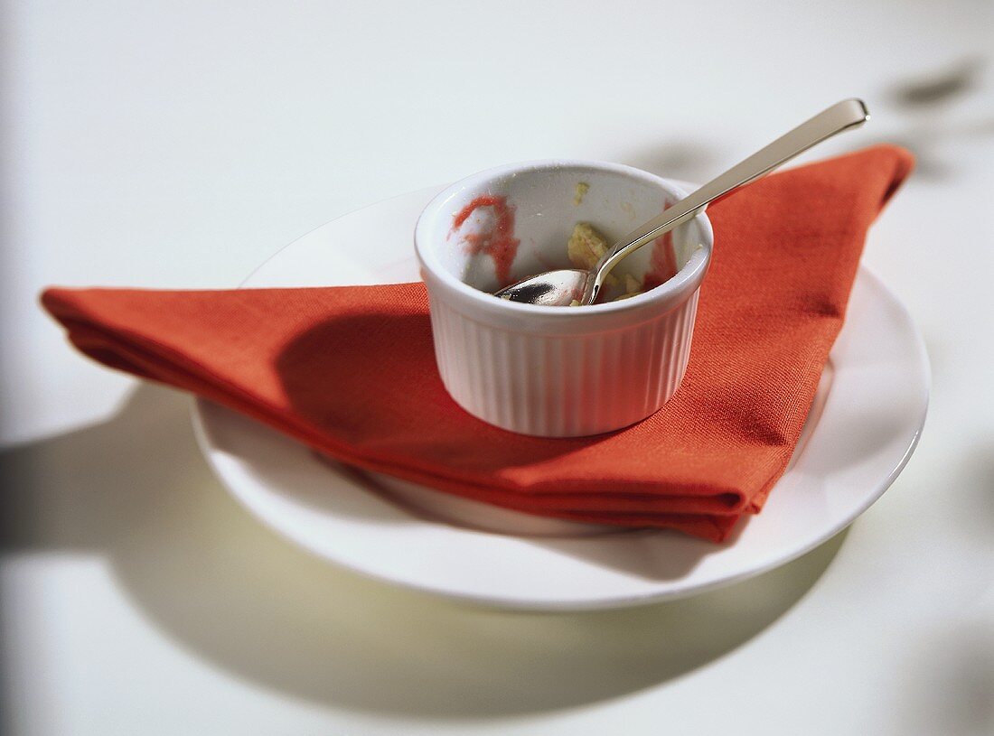 Empty souffle dish (all eaten) with spoon on napkin