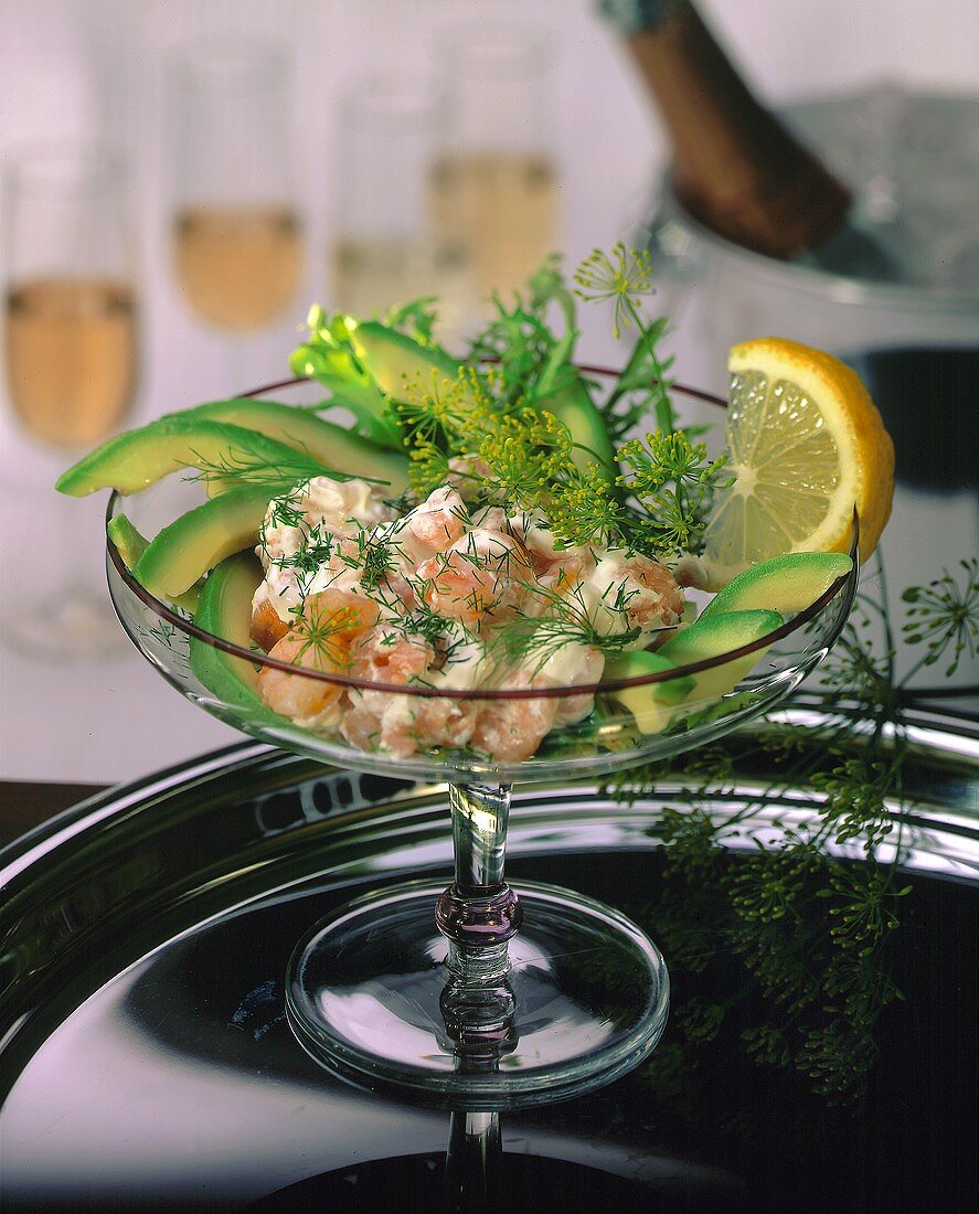 Shrimp cocktail with avocados and dill in glass bowl