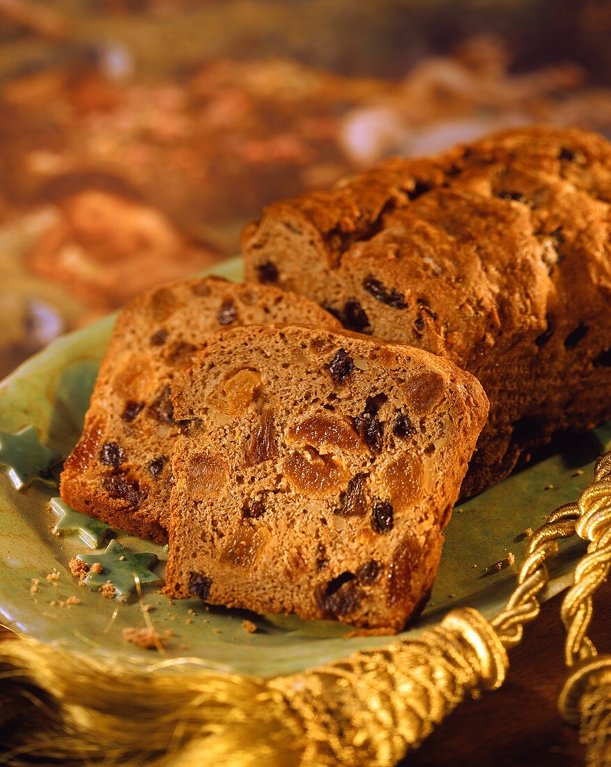 Früchtebrot, angeschnitten, auf grüner Platte