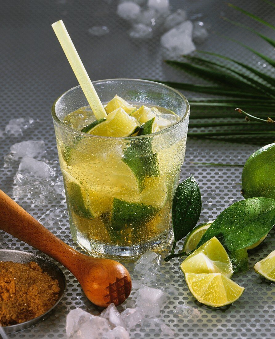 Caipirinha mit Limettenschnitzen und Eiswürfeln