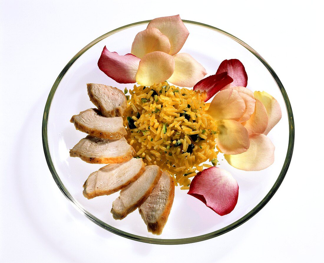 Hähnchenbrust mit Reis und Rosenblättern auf Glasteller