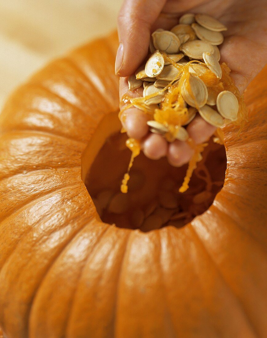 Hand Removing Pumpkin Seeds from Pumpkin