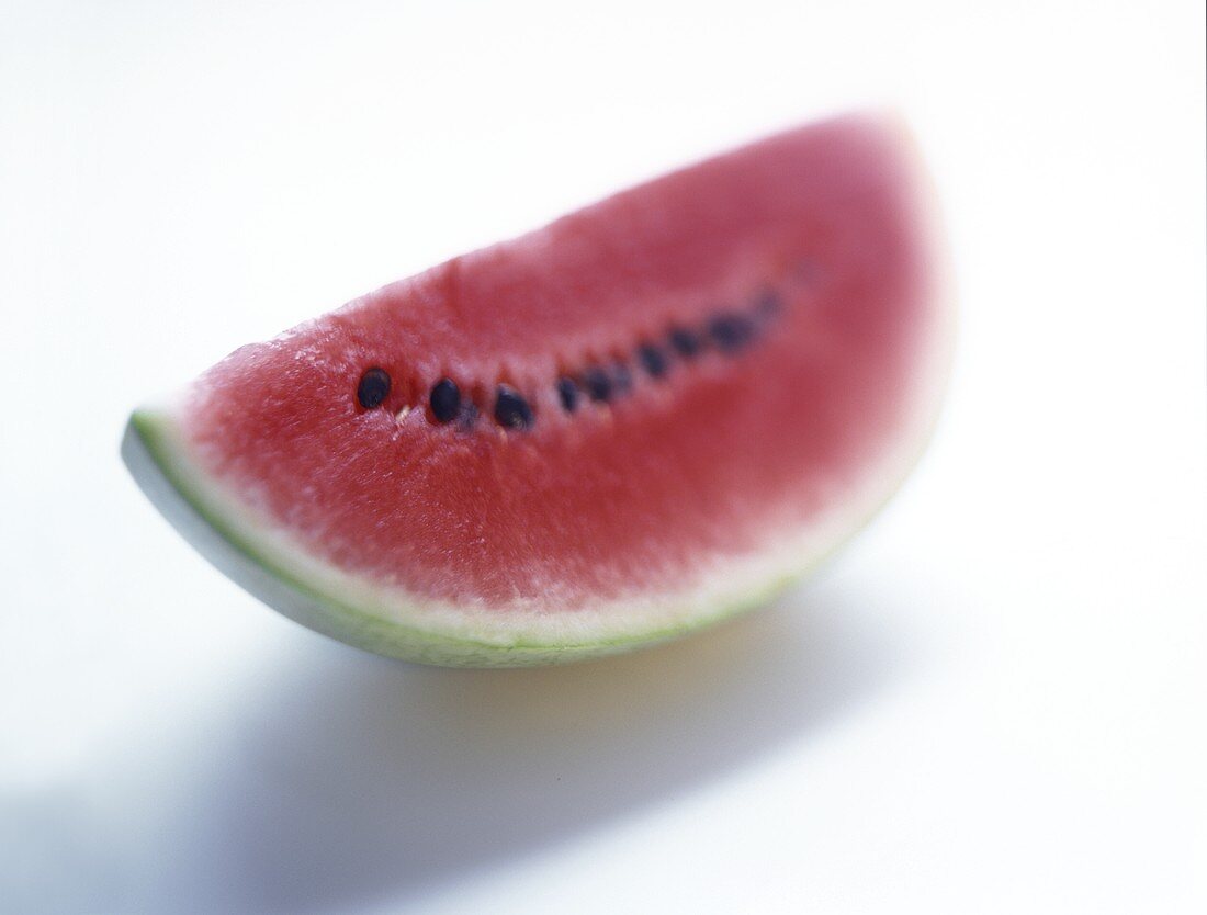 Ein Wassermelonenschnitz auf weißem Untergrund