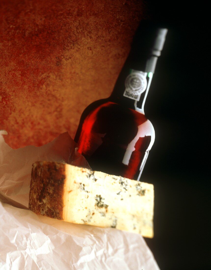 A Blue Cheese Wedge with a Bottle of Red Wine