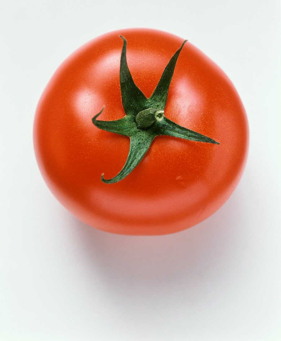 Eine Tomate (Oberseite) auf weißem Untergrund