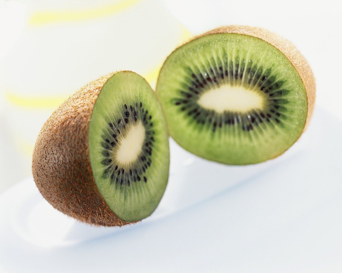 Two kiwi fruit halves on white plate