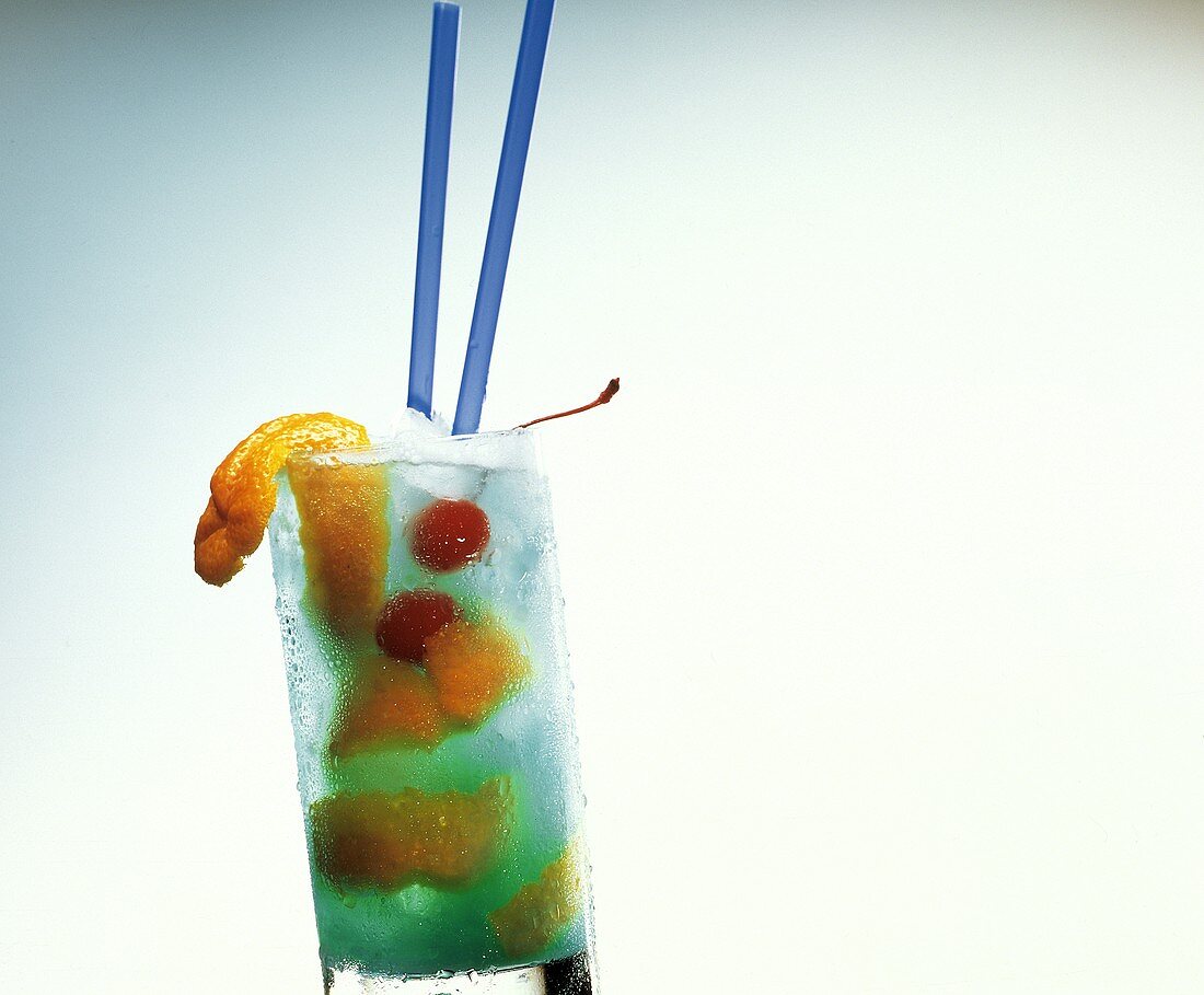 Blue Cobra Cocktail mit Orangenschalen und Cocktailkirschen