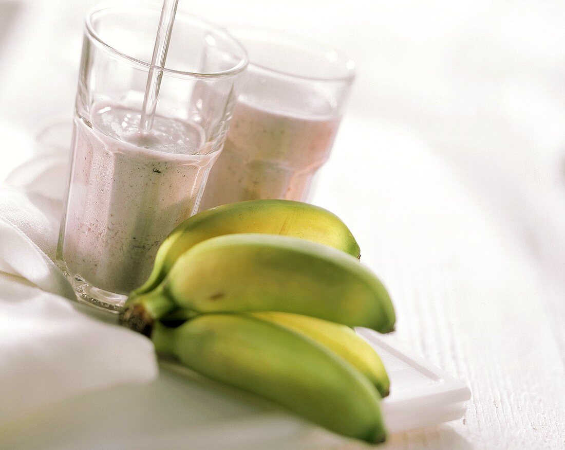Heidelbeer-Bananen-Milch in zwei Gläsern; Deko: Bananen