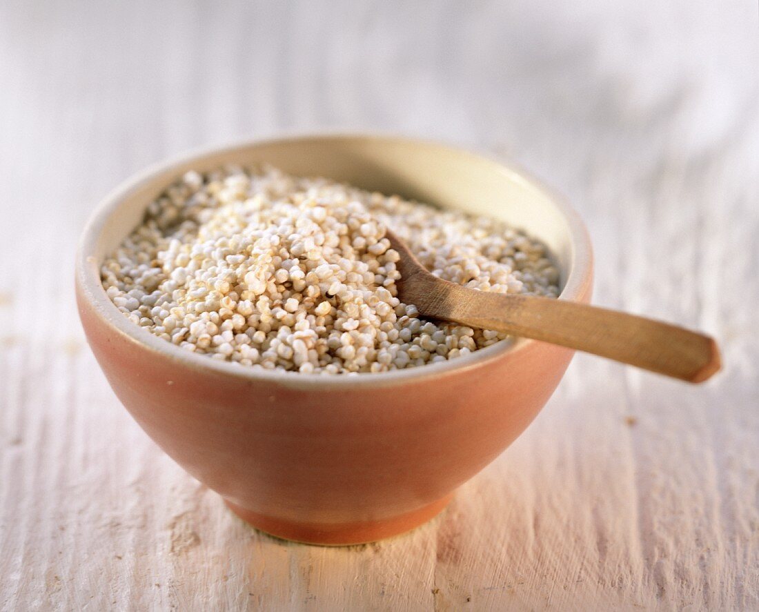 Millet in a bowl with wooden spoon