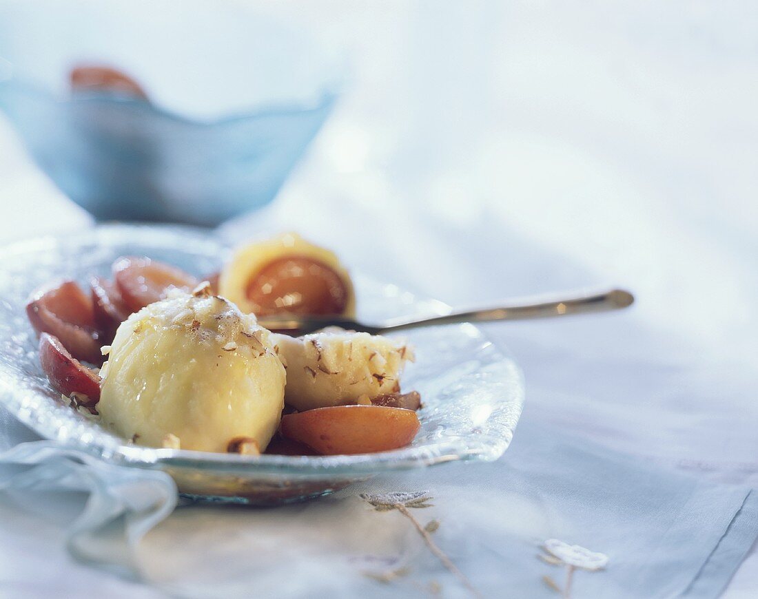 Zwetschgenknödel mit gehackten Haselnüssen auf Teller