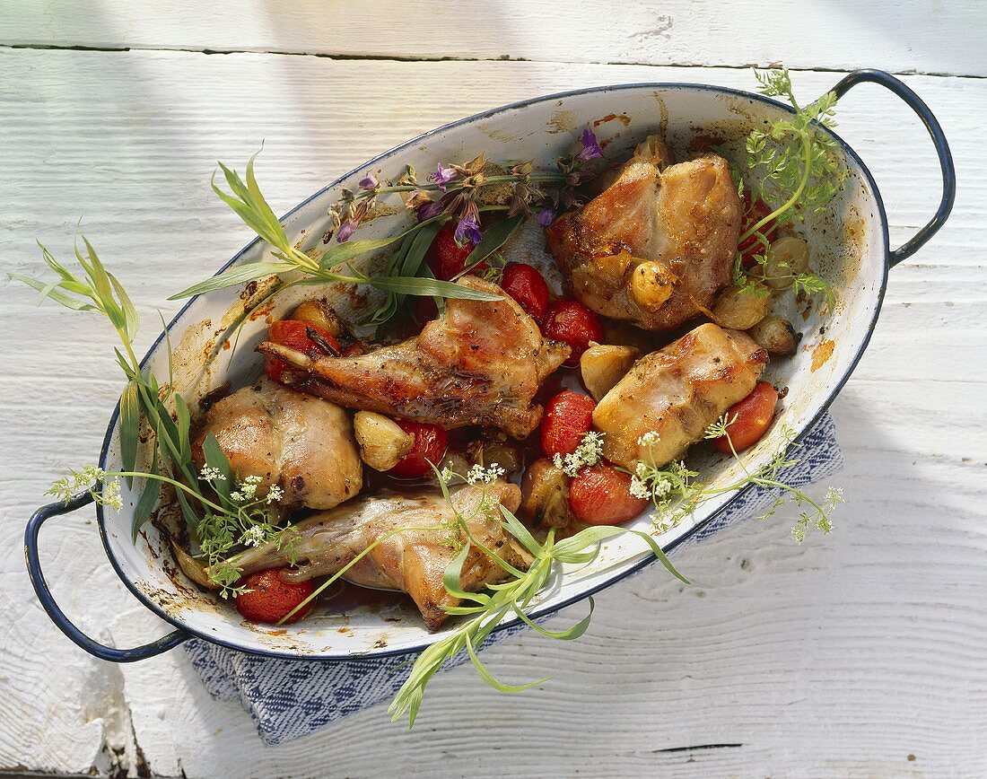 Braised rabbit with tomatoes & herbs in roasting dish