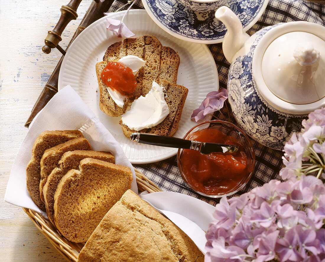 Dinkel-Toastbrot, angeschnitten, mit Marmelade; Teekanne