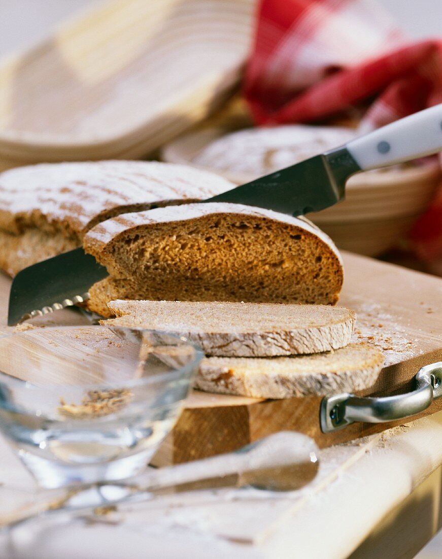 Dinkel-Gewürzbrot, mit Messer angeschnitten auf Schneidebrett