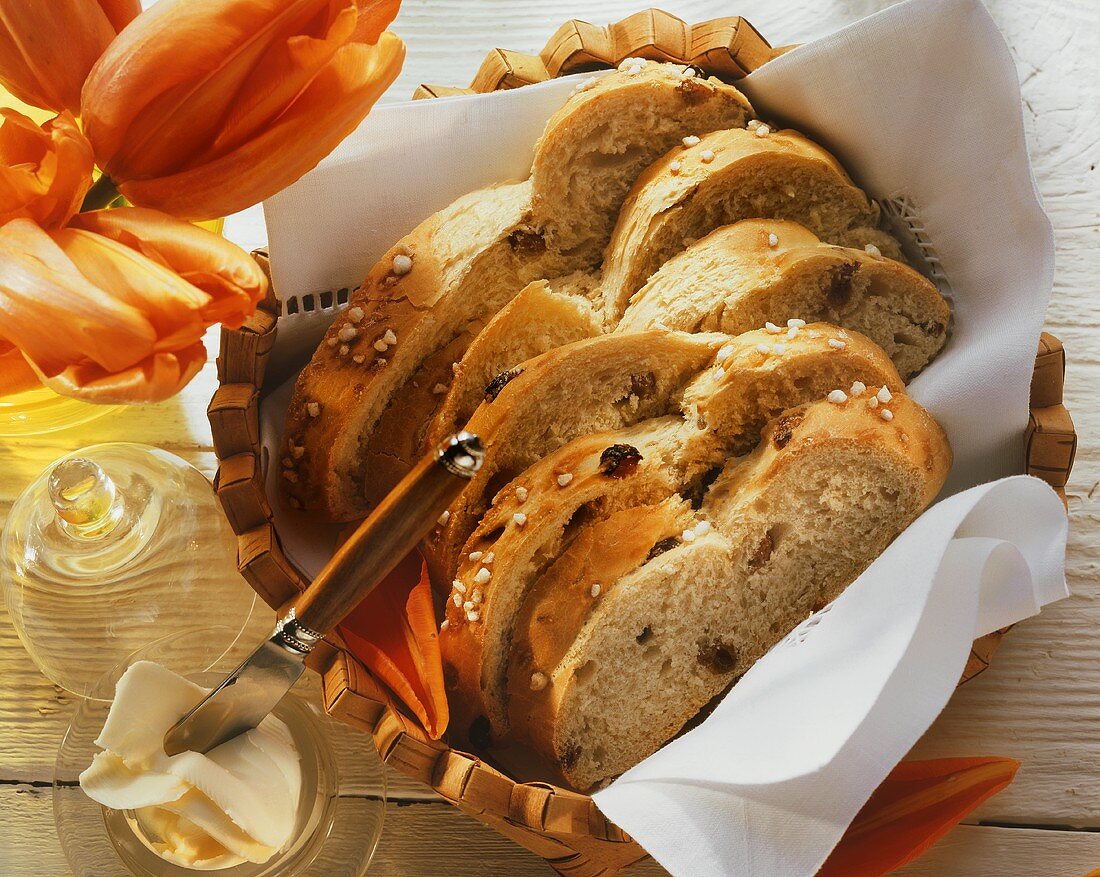 Raisin plait with sugar, a few slices in bread basket