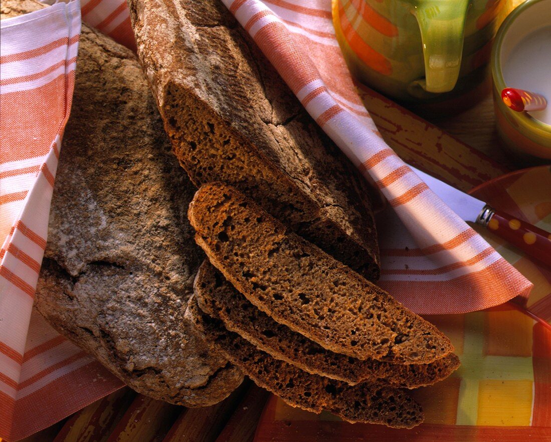Six-grain bread with a few slices on kitchen cloth