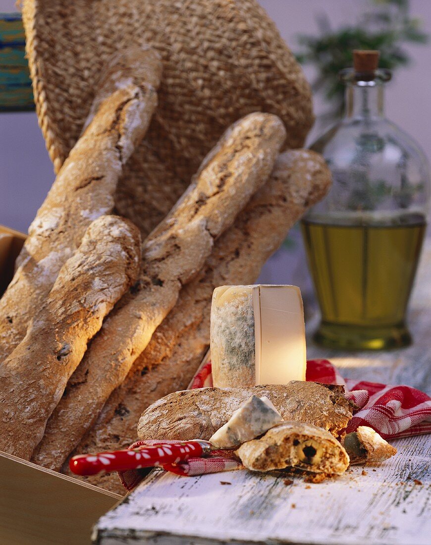 Olive baguette with cheese; décor: straw hat & olive oil