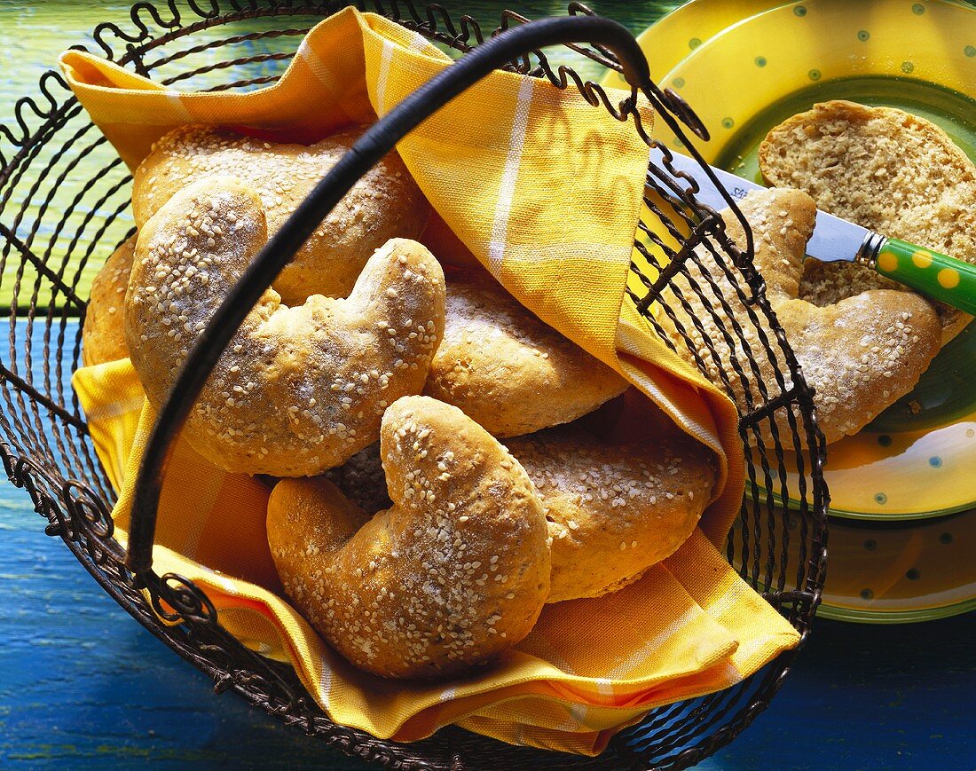 Mixed grain croissants in wire basket and on plate with knife