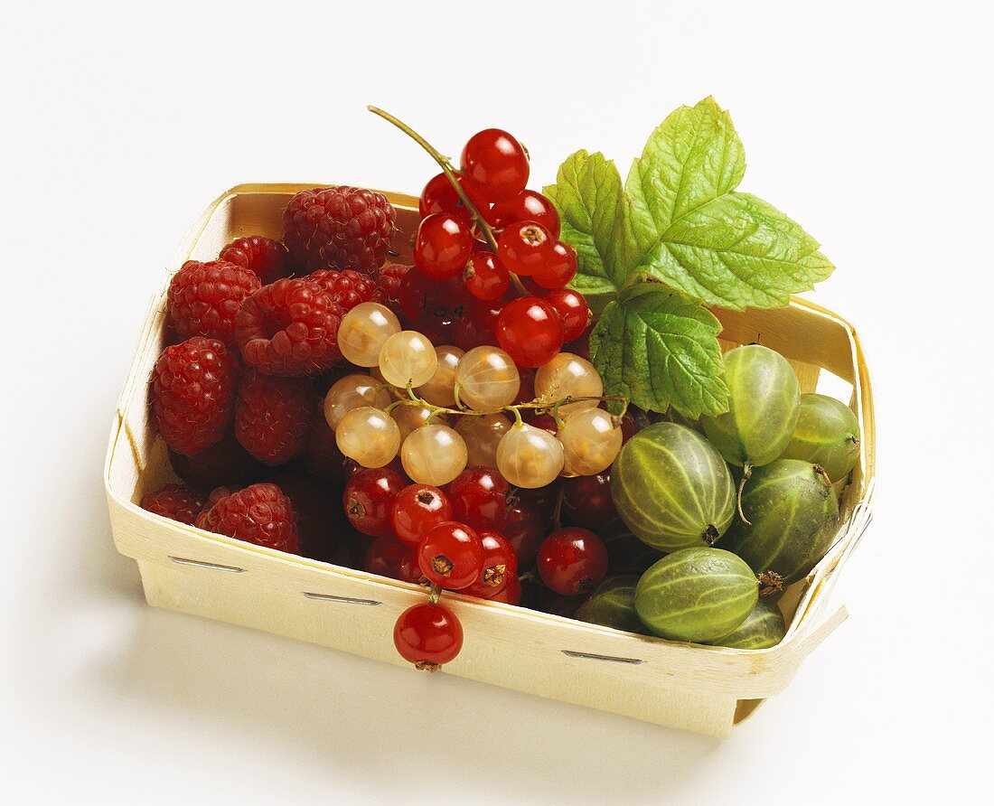 Various berries with redcurrant leaf in chip basket