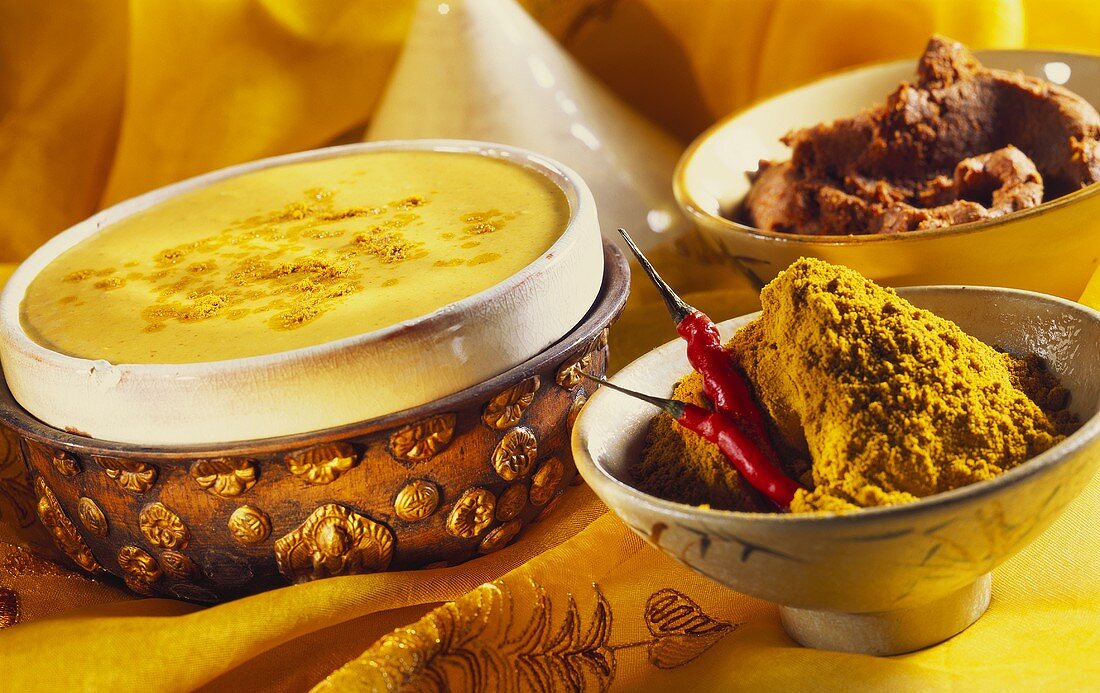Currysahne in einer Schale; Currypulver und Currypaste