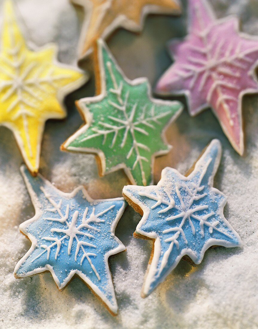Colourfully iced cinnamon leaves on sugared background