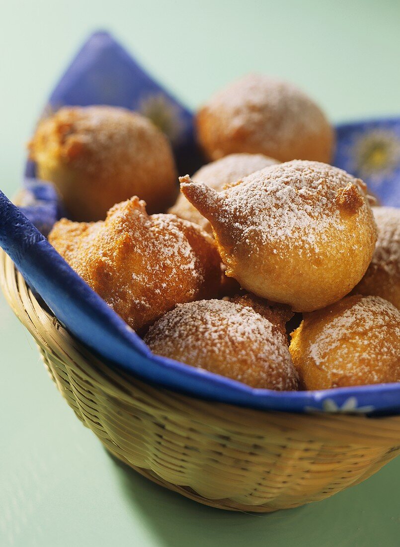 Deep-fried quark balls with icing sugar in a bread basket