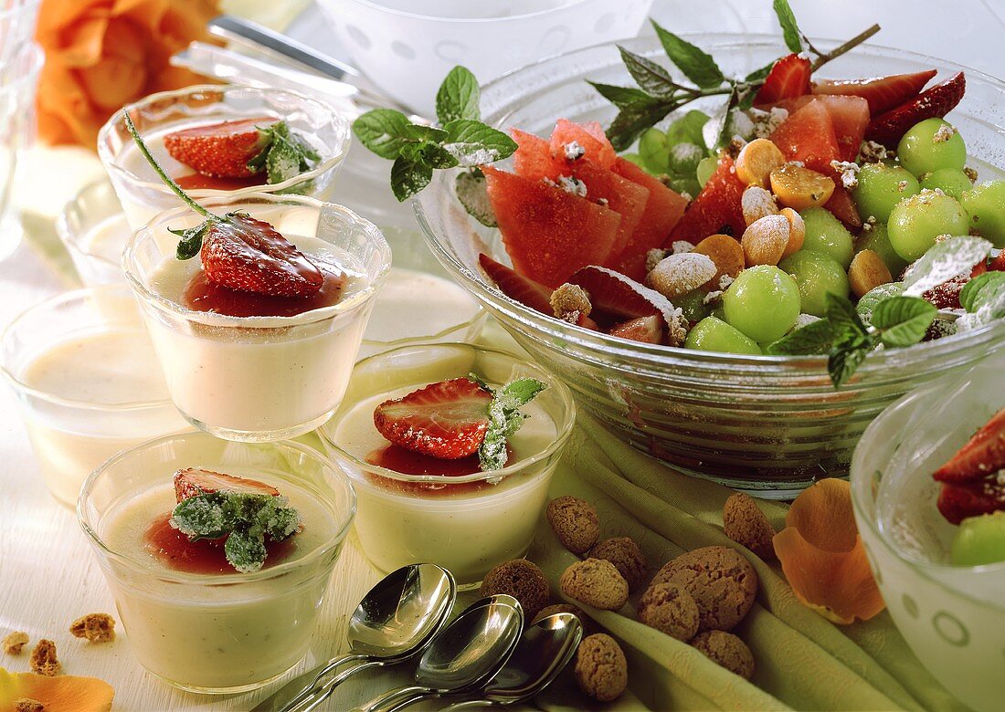 Panna cotta in small bowls, fruit salad and amaretti
