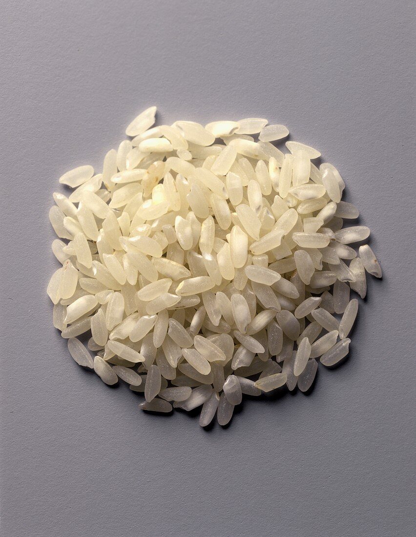 A heap of white short grain rice on a grey background