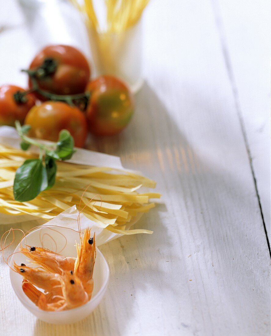 Still life with shrimps, noodles, tomatoes and basil