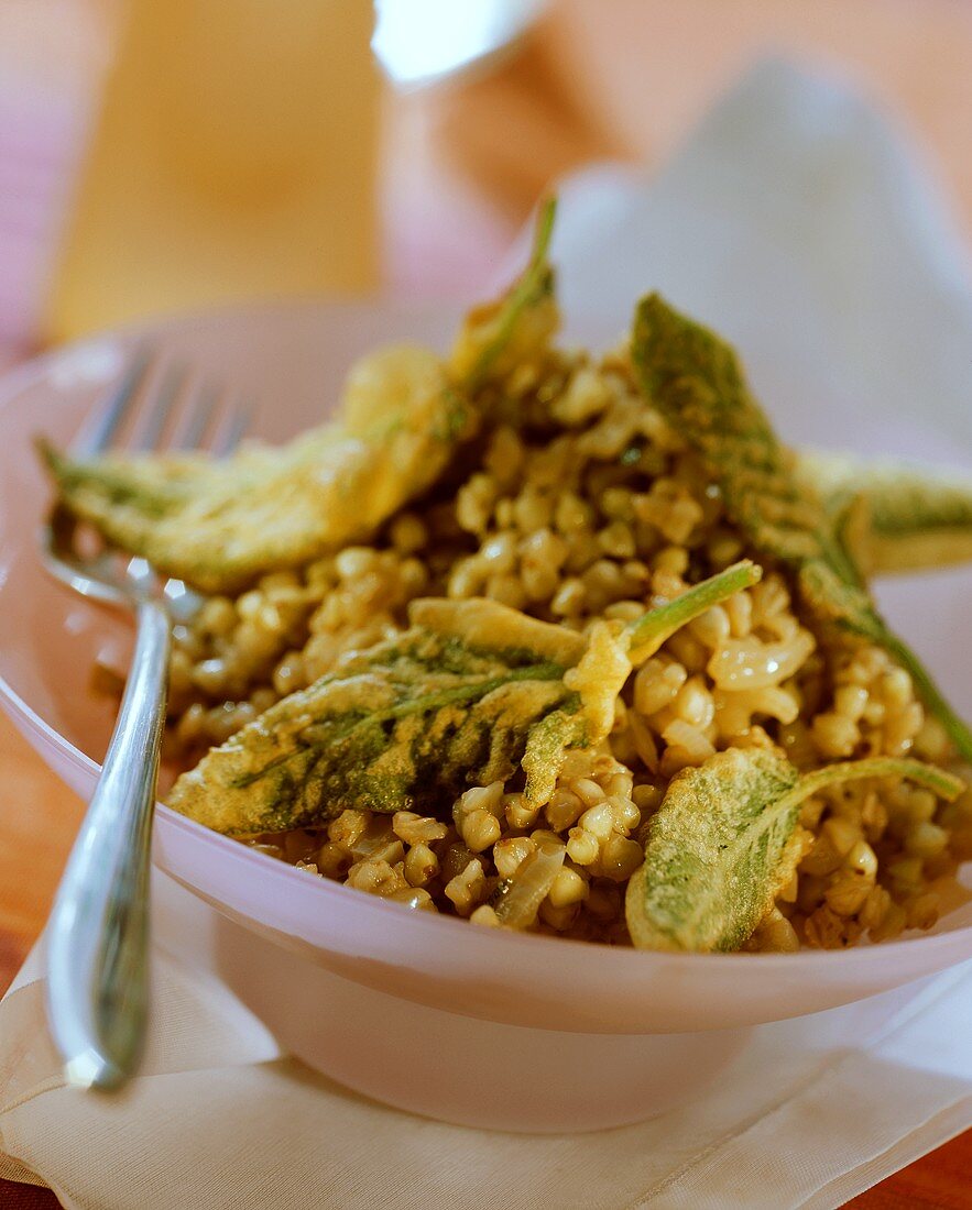 Buckwheat with sage leaves in bowl with fork