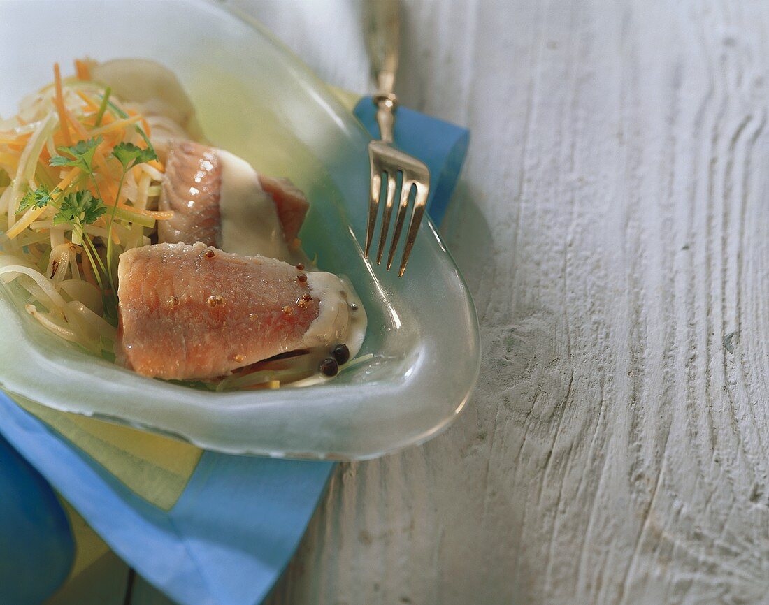 Catfish in root vegetable stock with cream sauce on plate