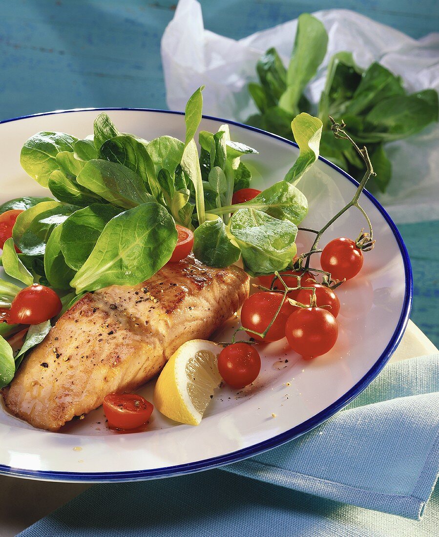 Lachs mit Feldsalat und Kirschtomaten auf Teller