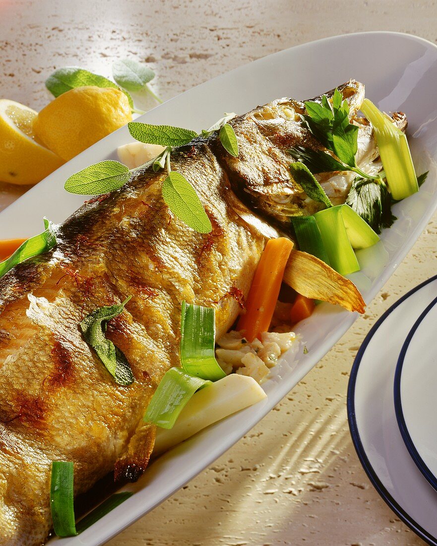 Stuffed pike with soup vegetables and sage on plate