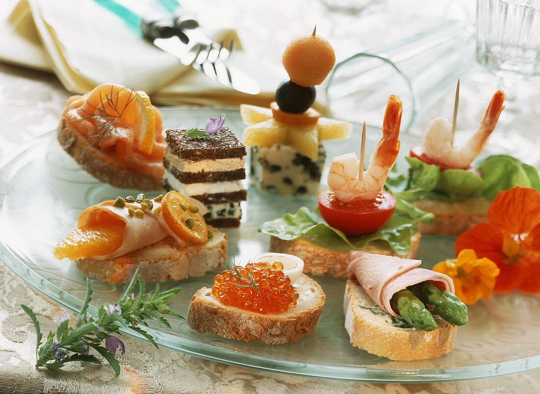 Various snacks and canapés on a glass plate