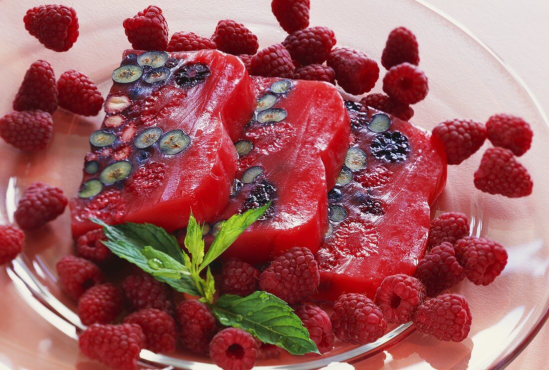 Forest fruit terrine with fresh raspberries on glass plate