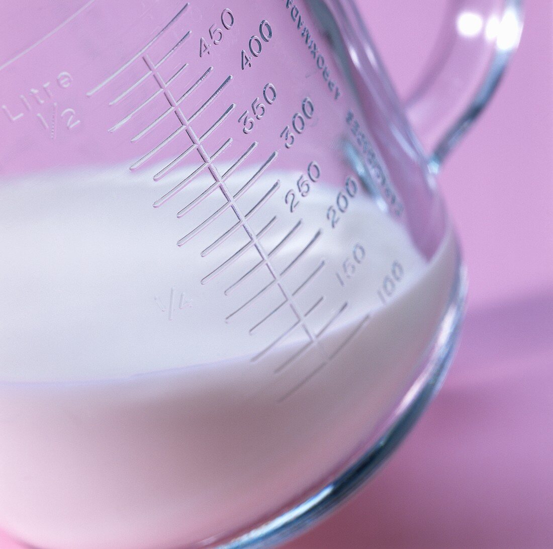 Glass measuring jug with milk