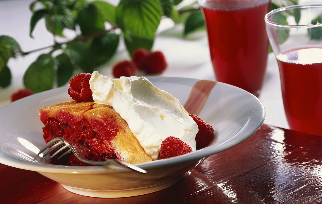 Ein Stück Charlotte mit Himbeeren und Sahne