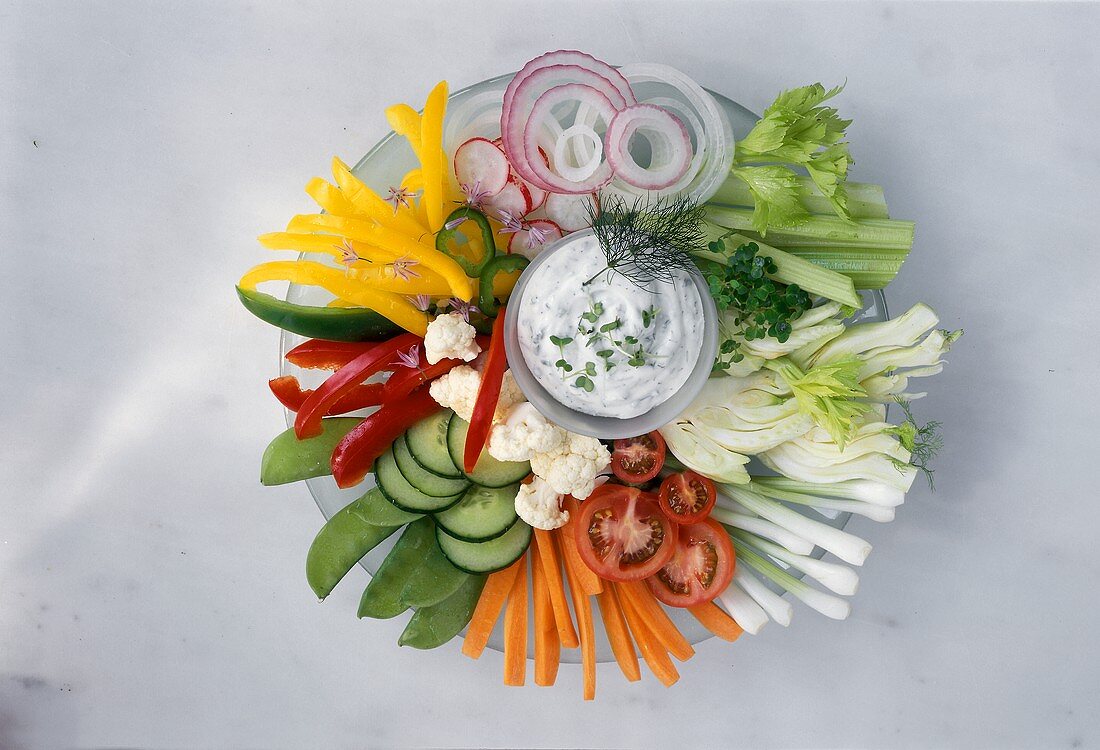 Plate of raw vegetables with herb quark dip 