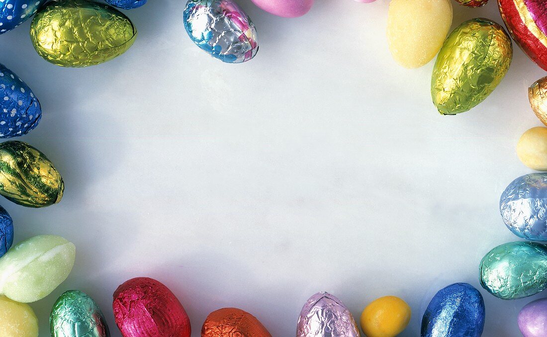 Coloured chocolate eggs, grouped round edge of picture