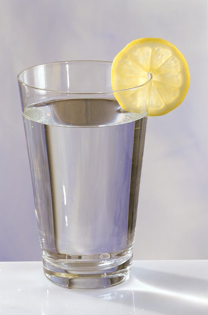Ein Glas Wasser mit Zitronenscheibe