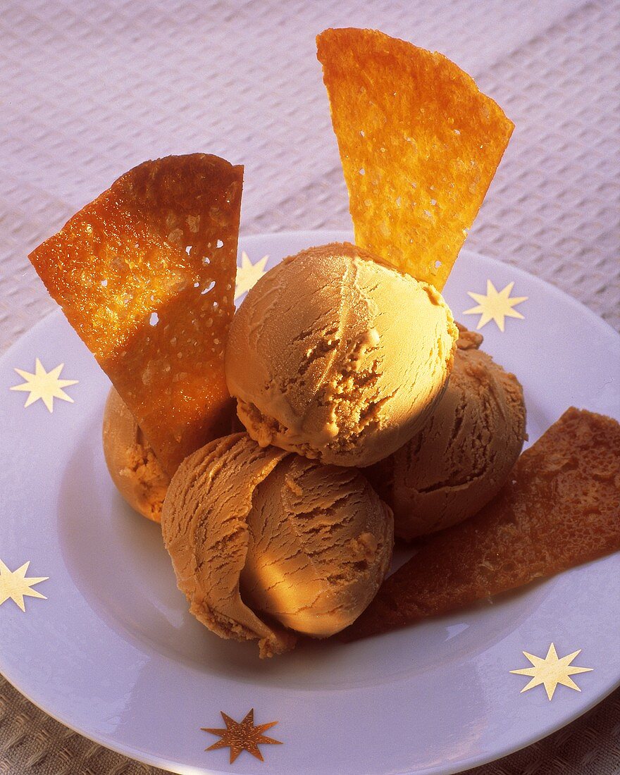 Caramel ice cream with caramelised wafers, on a plate